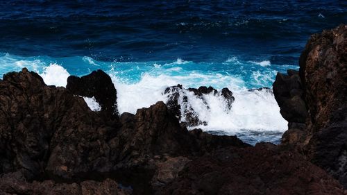 Scenic view of sea waves splashing on rocks