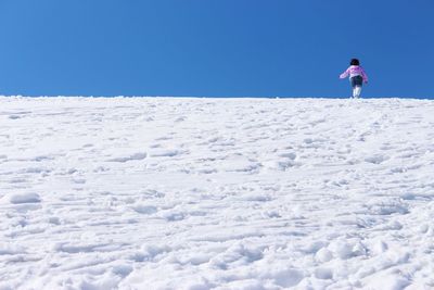 Man standing on snow against clear sky