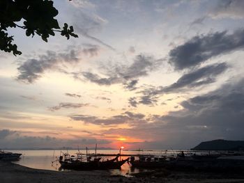 Silhouette boats moored on sea against sky during sunset