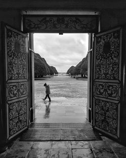 Boy seen through doorway during rainy season