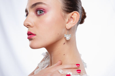 Close-up of young woman against white background