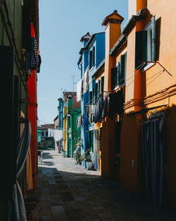 Alley amidst residential buildings against sky