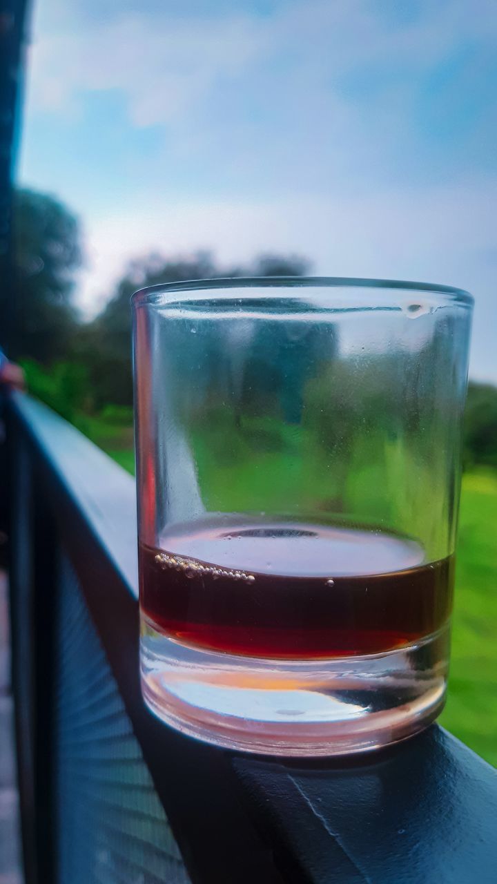 drink, refreshment, glass, food and drink, blue, drinking glass, household equipment, green, water, reflection, alcoholic beverage, alcohol, close-up, soft drink, nature, no people, sky, freshness, wine, focus on foreground, day, outdoors