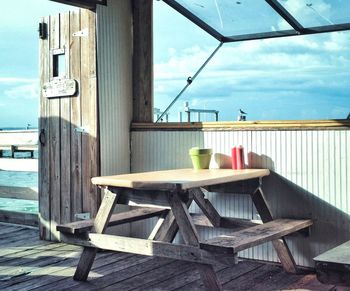 Wooden chairs and table against sky