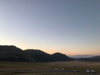 Scenic view of field against clear sky during sunset