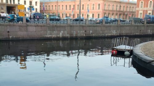 Boats moored in canal by buildings in city