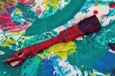 Full frame shot of colorful table with paintbrush