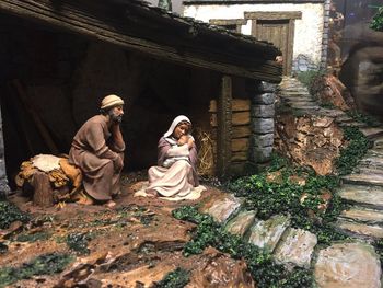 Statue of woman sitting outside building