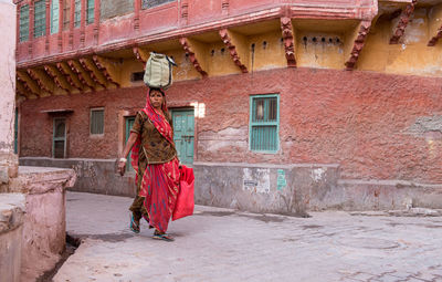 Rear view of a woman walking on building