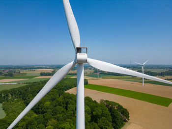 Low angle view of windmill against blue sky