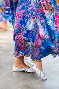 Low section of woman walking on street in city