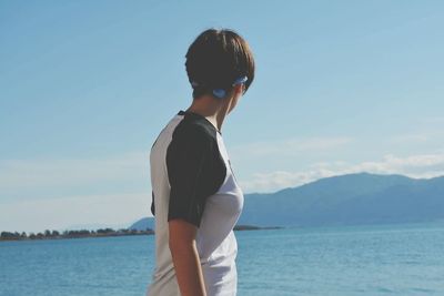 Woman looking at sea against sky