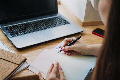 Taskmanager, to do list, boosts productivity, close up of female hands and paper to do list in