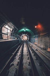 Illuminated railroad tracks at night