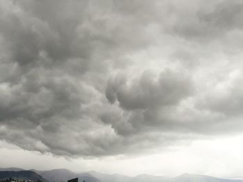 Low angle view of storm clouds over mountains