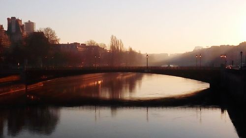 Bridge over river at sunset