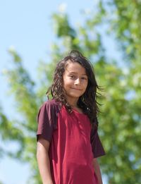 Portrait of girl standing against tree