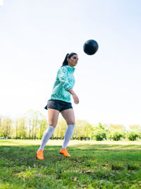 Full length of woman playing with ball on field