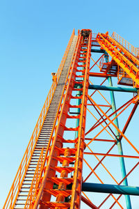 Low angle view of construction site against clear blue sky