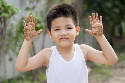 Portrait of boy with arms raised