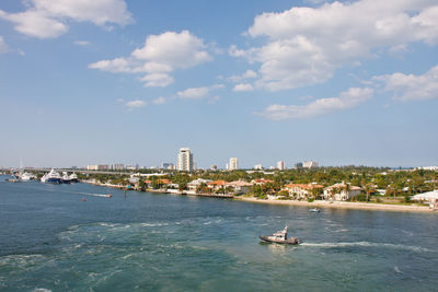 Boats in sea against buildings in city