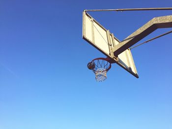 Low angle view of basketball hoop against clear blue sky