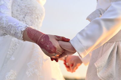 Midsection of couple holding hands