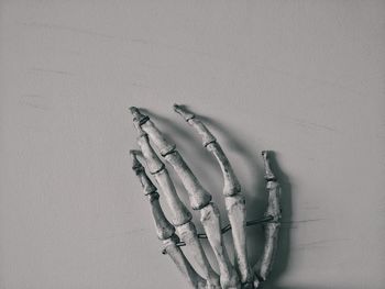 Close-up of hand on table against wall