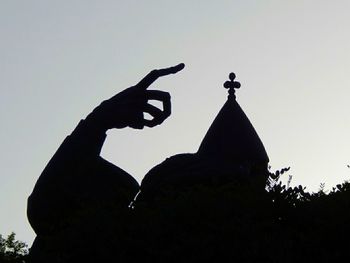 Low angle view of silhouette hand against clear sky