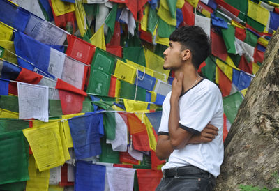 A male tourist looking to tibetan buddhist prayer flags in outdoors 