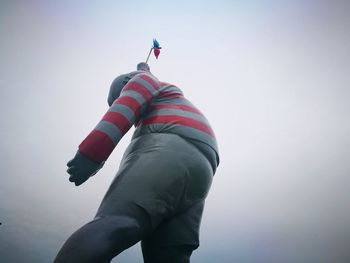 Low angle view of person against clear sky