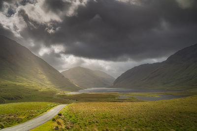 Road leading trough doolough valley with lakes andmountain range, ireland