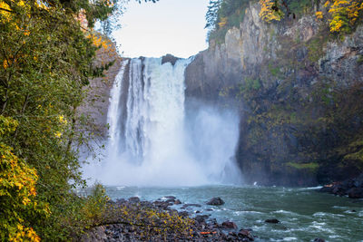 Scenic view of waterfall against sky