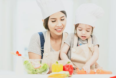 Portrait of a smiling young woman preparing food