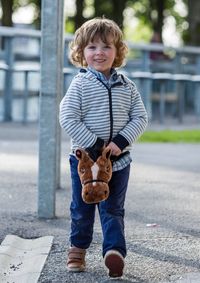 Portrait of young boy with toy horse