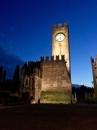 Low angle view of clock tower against sky at night