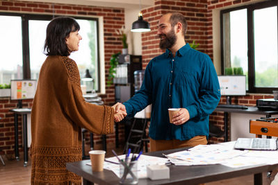 Smiling business person shaking hands in office