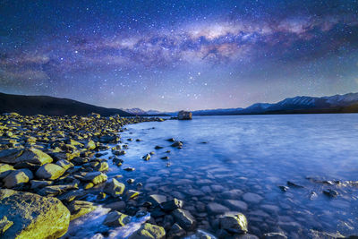 Scenic view of lake against sky at night