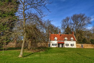House amidst trees and buildings against sky