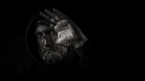 Close-up portrait of man against black background