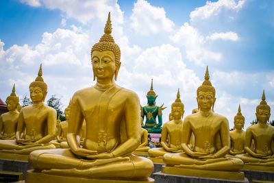 Buddha statue against temple against sky
