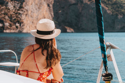 Rear view of woman in boat against sea