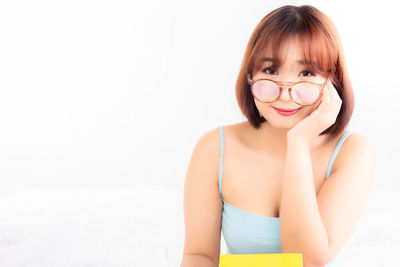 Portrait of smiling young woman against white background