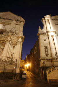 View of illuminated street amidst buildings at night