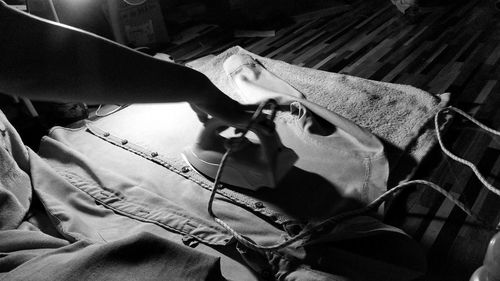 Cropped hand of person ironing at home