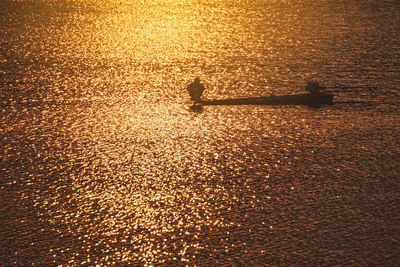 High angle view of shadow on sea against sky during sunset