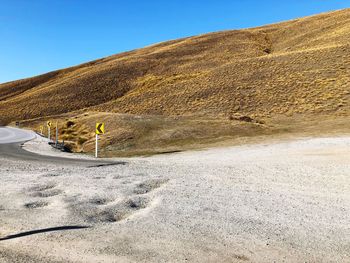 Scenic view of desert against clear blue sky