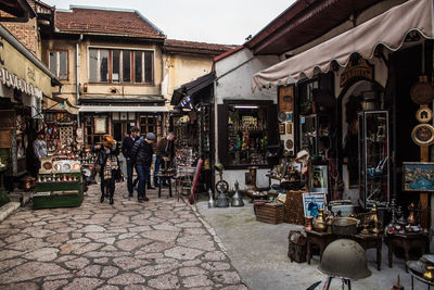 People walking on street amidst buildings in city