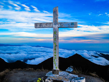 Cross on land against sky