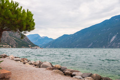 Scenic view of sea and mountains against sky